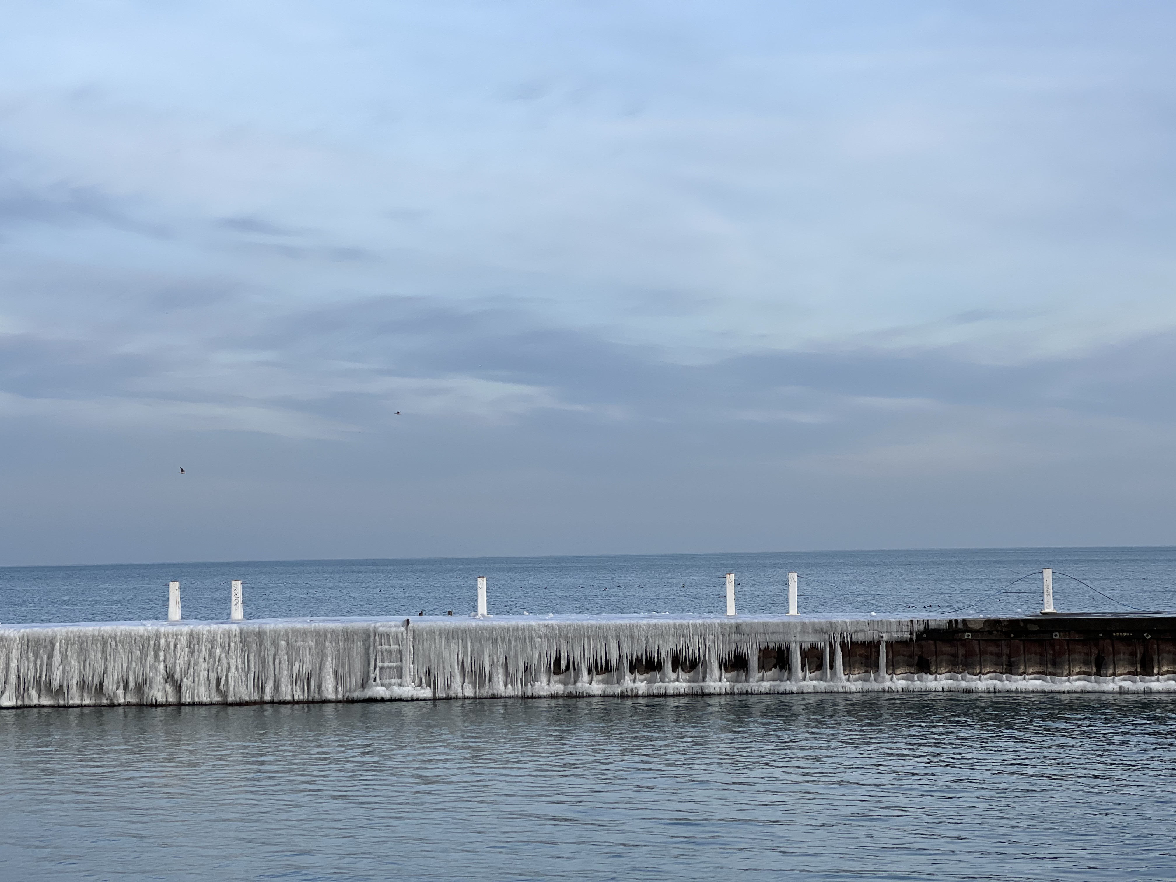 The picture of a concrete barrier in Lake Michigan covered in ice