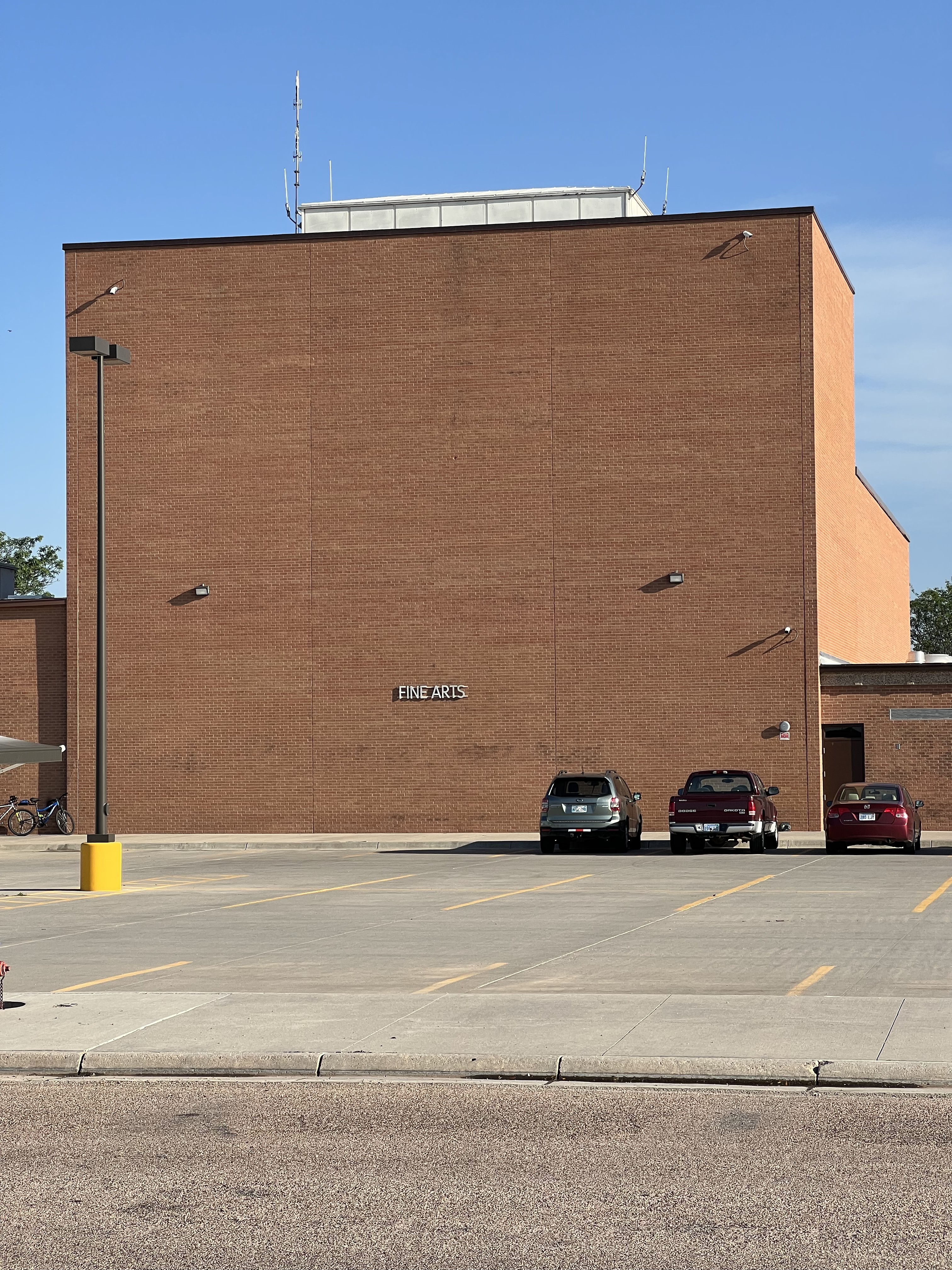 A monolithic brick building with a sign saying 'Fine Arts' on it